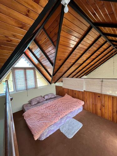 una camera da letto con letto rosa in mansarda di Nadi Kinare a Bhimtal