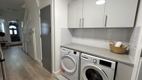a kitchen with a washer and dryer in a room at Spacious 3 Guests Ensuite Room,Piccadilly Line,Fast Access Central London 1 in London