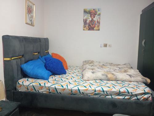 un letto in una stanza con cuscini blu sopra di Mandeko a Abidjan