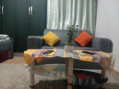 Sofá azul con almohadas coloridas y mesa en Mandeko, en Abiyán