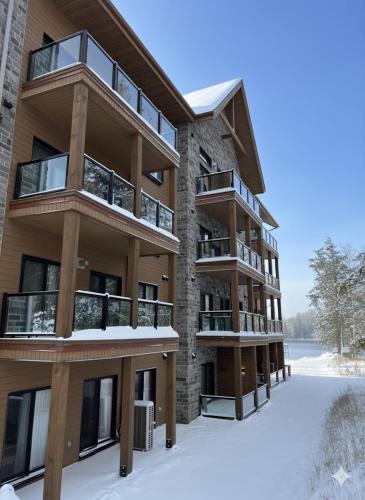 an apartment building with snow on the ground at Château Morritt in Mont-Tremblant