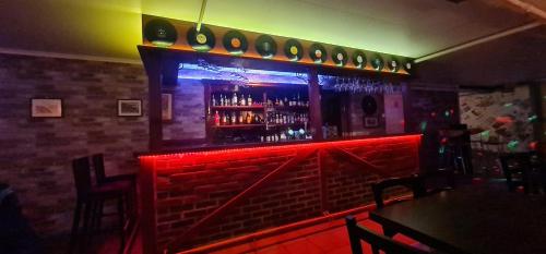 un bar con una panca rossa e uno scaffale con le bottiglie di Sauda Bed & Breakfast a Sauda