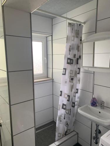 a bathroom with a shower curtain and a sink at GMA Apartment T4 in Kappel-Grafenhausen