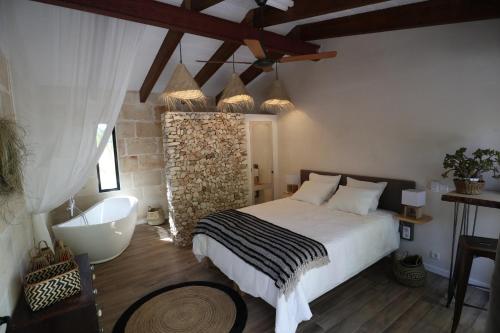 费雷列斯La Casa Menorca的一间带大床和浴缸的卧室