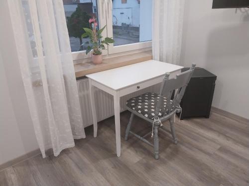 a desk and a chair in a room with a window at Flora Comfort Inn in Oberhausen