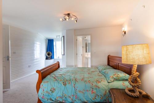 een slaapkamer met een bed en een lamp bij Boathouse Bliss in Heacham