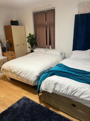 a bedroom with two twin beds and a rug at Premiership Lodge in Beeston Hill