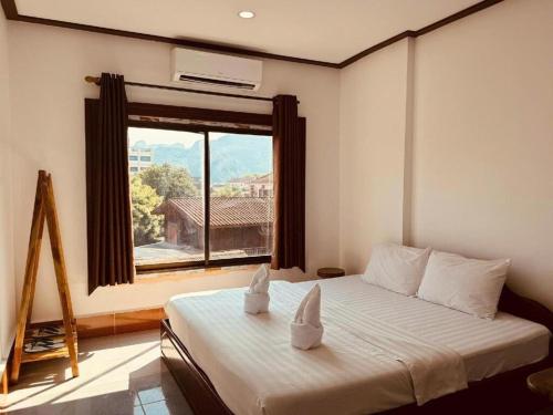 Ένα ή περισσότερα κρεβάτια σε δωμάτιο στο Walking Street Hotel Vang Vieng
