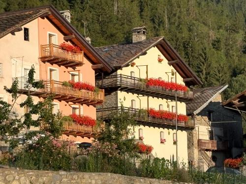 a large house with flower boxes on its balconies at Affittacamere L'Abri in Etroubles
