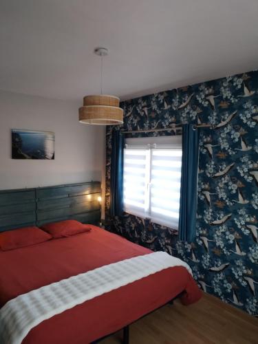 een slaapkamer met een rood bed en een raam bij Cajem in Étretat