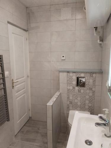 een witte badkamer met een wastafel en een toilet bij Cajem in Étretat