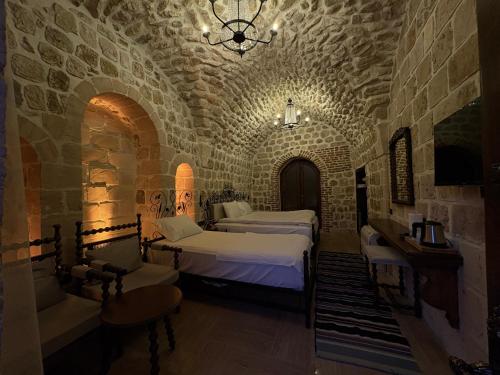 una camera con due letti in una stanza in pietra di Arami Han Konağı a Mardin