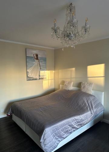 a bedroom with a large bed and a chandelier at Deck 8 in Timmendorfer Strand