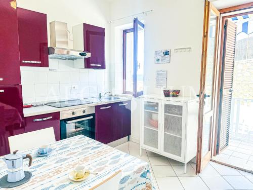 een keuken met paarse kasten en een tafel. bij Carla 1 in Campese