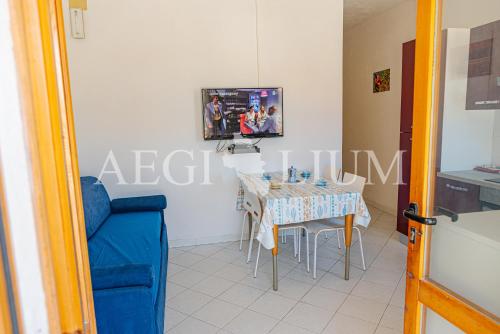 een woonkamer met een tafel en een tv bij Carla 1 in Campese