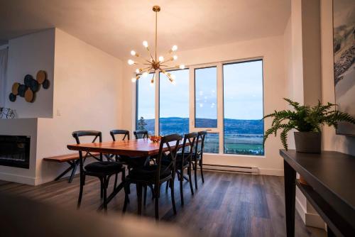 een eetkamer met een tafel en stoelen en een groot raam bij Luxury Coffee Bean Condo - Pool & Stunning View in Baie-Saint-Paul