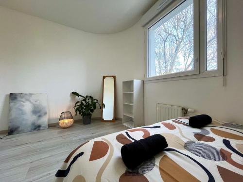 ein Schlafzimmer mit einem Bett und einem großen Fenster in der Unterkunft Le Casual avec parking - 5 pers - Proche Gare Vénissieux - à 15 min de Lyon in Vénissieux