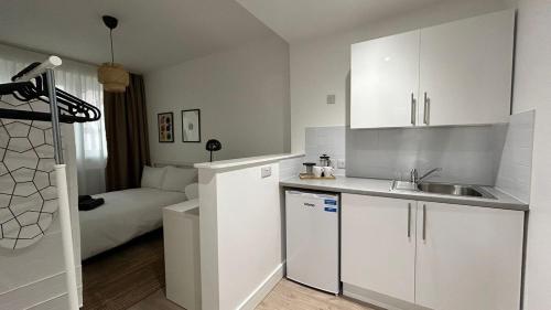 a kitchen with a sink and a couch in a room at Modern Private Ensuite Room,Piccadilly Line,Stylish & Quiet Stay 2 in London