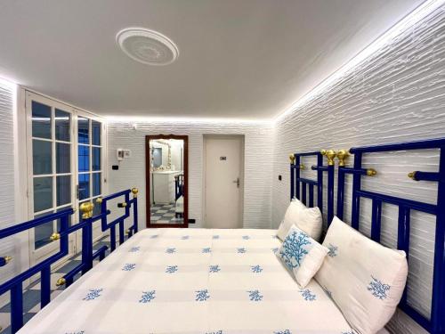 een slaapkamer met een blauw en wit bed met kussens bij Villa Nazarena in Torre Suda