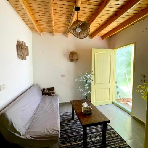 a living room with a couch and a table and a door at Amir House cozy studio in Dahab