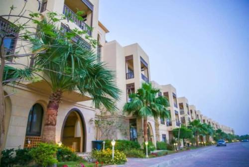 een gebouw met palmbomen naast een straat bij Golf Heights Resort Nabk Bay Sharm El Sheikh One Bedroom Apartment in Sharm El Sheikh