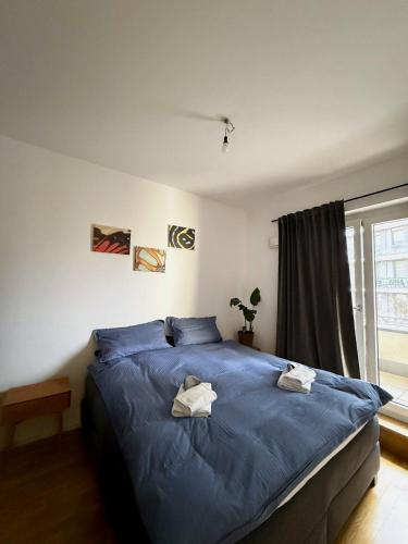 een slaapkamer met een groot blauw bed en handdoeken bij Apartment und Ferienwohnung Scharnhorststraße, Berlin-Mitte in Oranienburg