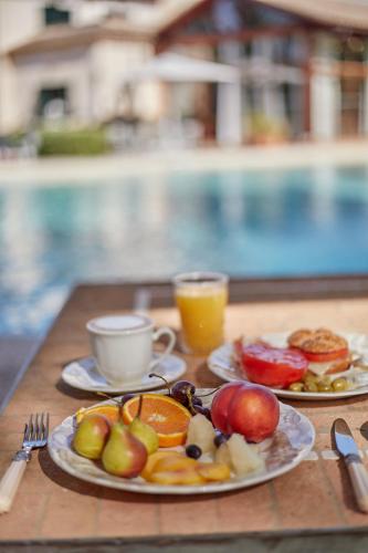 a table with two plates of fruit and a cup of coffee at Agroturismo Sa Vinya des Convent in Inca