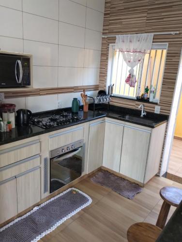 a kitchen with a stove and a sink at Edicula do Sidnei in Brotas