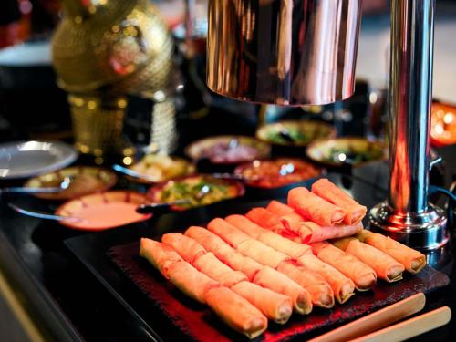 a bunch of hot dogs on a grill with other foods at Ibis Riyadh Olaya Street in Riyadh