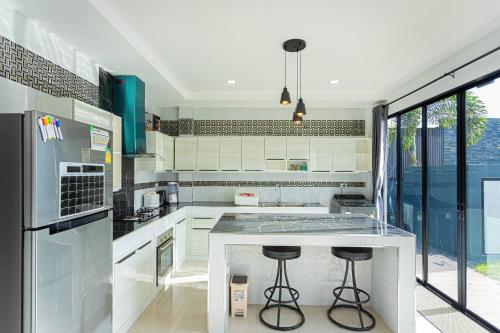 a kitchen with a counter and two bar stools at Kathu V pool villa 171 in Kathu