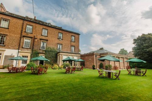 a group of tables and chairs in front of a building at Bannatyne Hotel Darlington in Darlington