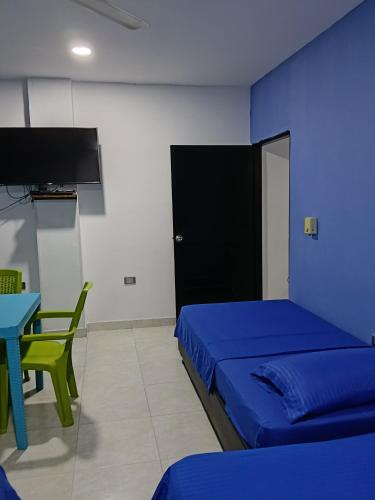 a room with a bed and a table and a tv at Apartamentos Erica 303 en el Centro histórico de Santa Marta in Santa Marta
