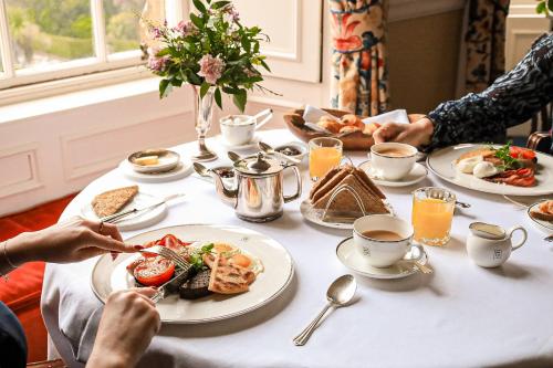 a group of people sitting around a table with food at Glenapp Castle in Ballantrae