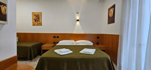 a bedroom with a bed with two towels on it at Hotel Zara Napoli in Naples