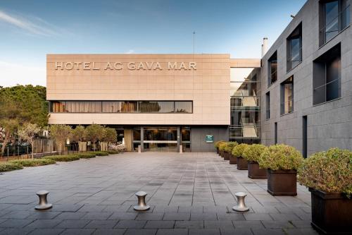 a building with a courtyard with potted plants in front at Sabàtic Gavà Mar, Barcelona, a Tribute Portfolio Hotel in Gavà