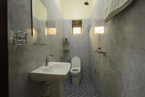 卡塞斯Kasese Airstrip Homestay的带水槽和马桶的浴室