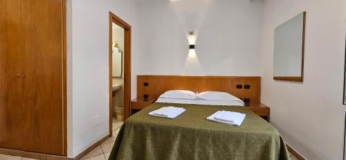 a bedroom with a bed with two white towels on it at Hotel Zara Napoli in Naples