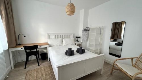 a bedroom with a bed with a desk and a mirror at Business-Ready Ensuite Room,Desk & Fast WiFi,Piccadilly Line 3 in London
