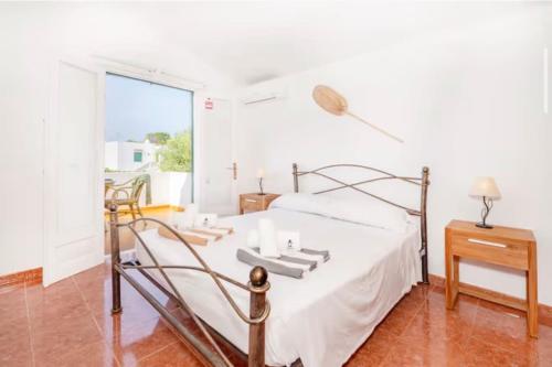 a bedroom with a bed and a large window at Villa Jultomas in Cala en Bosc