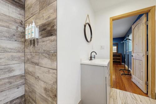 een badkamer met een wastafel en een houten muur bij Dynasty Palace in Hendersonville