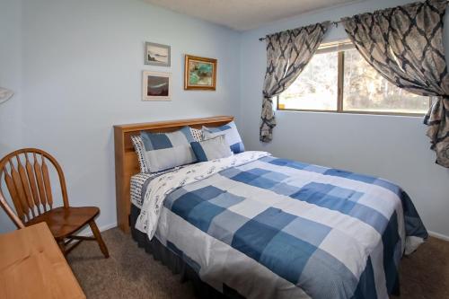 una camera con un letto blu e bianco e una finestra di Ocean Treasures a Smith River