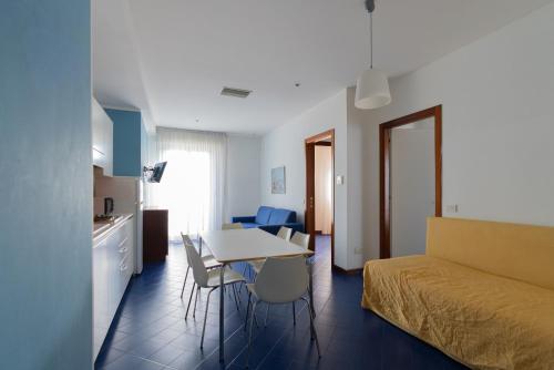 ein Zimmer mit einem Bett, einem Tisch und Stühlen in der Unterkunft Residence Adriatico in Gabicce Mare