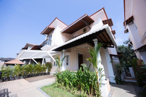 a white house with plants in front of it at ELIVAAS Signature Cygnus with Pvt pool in Mapusa