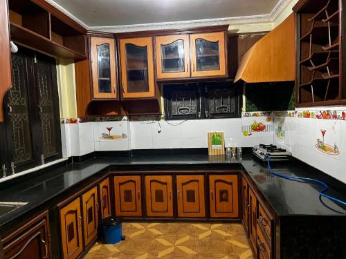 een keuken met houten kasten en zwarte aanrechtbladen bij Amelie Apartments and Stay Inn in Pokhara
