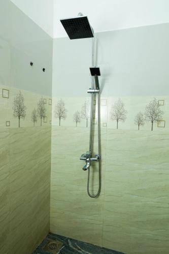 a shower in a bathroom with trees on the wall at Ever Top Resort Kithulgala in Kitulgala
