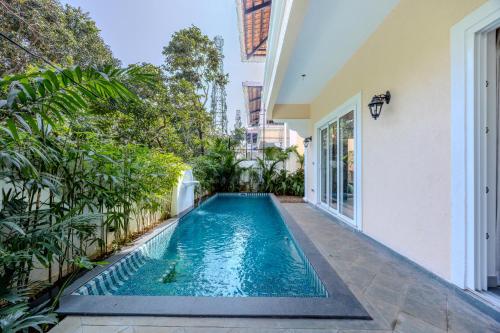 an infinity pool in the backyard of a house at ELIVAAS Signature Cygnus with Pvt pool in Mapusa