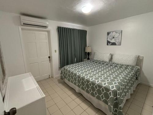 a bedroom with a bed and a window and a door at L'Esperance Hotel in Philipsburg