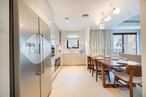 a kitchen and dining room with a table and a refrigerator at Bloomfields Executive 3BR Apt Fujairah Address in Fujairah
