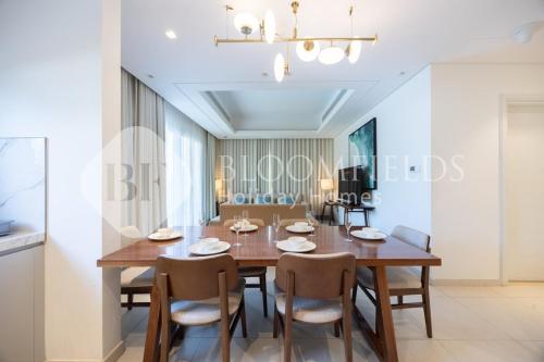 a dining room with a wooden table and chairs at Bloomfields Executive 3BR Apt Fujairah Address in Fujairah