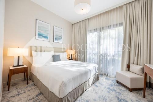 een slaapkamer met een bed en een raam bij Bloomfields Executive 3BR Apt Fujairah Address in Fujairah